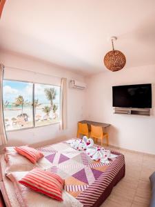 a bedroom with a bed with a view of the beach at Flat Apart Hotel Marinas Tamandaré in Tamandaré