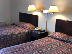 a hotel room with two beds and a telephone at Westwind Motor Inn Hotel in Drayton Valley +24 photos