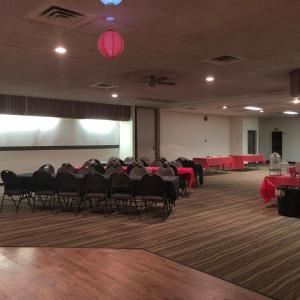 a conference room with tables and chairs and a projection screen at Westwind Motor Inn Hotel in Drayton Valley