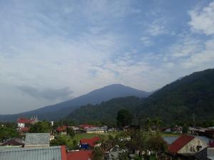 a view of a town with mountains in the background at Trivadoh Syariah Hotel in Padangpanjang