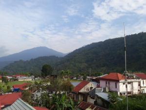 een klein stadje met bergen op de achtergrond bij Trivadoh Syariah Hotel in Padangpanjang
