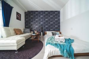 東京にあるK&K Apartment Kita-Akabane #202のリビングルーム(ソファ、白いベッド付)