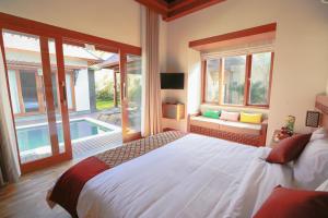 ein Schlafzimmer mit einem großen Bett und einem Pool in der Unterkunft Villa Niketan Sanur - Three bedroom, Sanur, Near Icon Mall, Harbor in Sanur