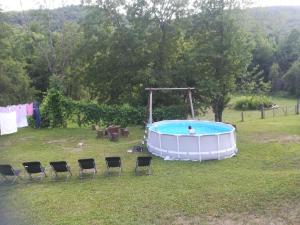 een zwembad in een tuin met stoelen en een persoon erin bij Guesthouse Bubalo in Drežnik Grad