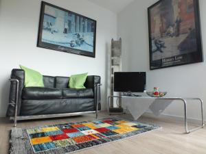 sala de estar con sofá de cuero negro y mesa en Wohnung Weitblick Haan, en Haan