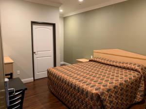 a bedroom with a bed and a white door at El Rey Inn in Gardena
