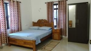 a bedroom with a bed and a dresser and windows at Lakeview homestay in Kokkānisseri
