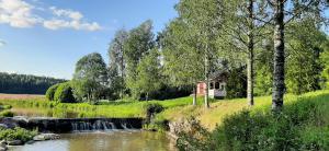 a small cabin next to a river with a waterfall at Störsby Bed & Breakfast in Lappers