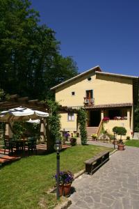 ein Haus mit einer Terrasse mit einem Tisch und Stühlen in der Unterkunft Hotel Relais Valle Orientina in Pitigliano