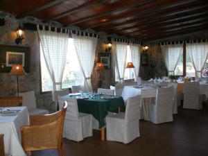 un comedor con mesas blancas y sillas blancas en La Quinta de los Enebrales, en El Hoyo de Pinares