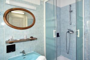 W łazience znajduje się prysznic, umywalka i lustro. w obiekcie Hotel de la gare w mieście Cosne-Cours-sur-Loire