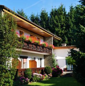 a house with flower boxes on the balcony at Pension Kitty in Pörtschach am Wörthersee