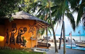 a small building with graffiti on it next to the beach at The Mud - Eco Hotel in Ban Bang Po