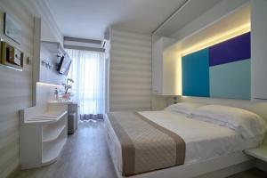 a bedroom with a large bed and a desk at Hotel Helen in Caorle