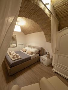 a bedroom with a bed and a brick wall at Residenza Porta Perlici Assisi Apartment in Assisi