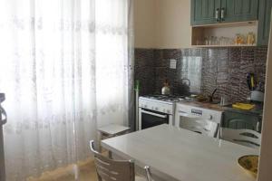 a kitchen with a white table and a stove at Apartment Khimshiashvili 9 in Batumi