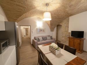 salon z kanapą i stołem w pokoju w obiekcie Residenza Porta Perlici Assisi Apartment w Asyżu