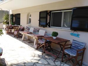 eine Terrasse mit Stühlen, Tischen und einem Fenster in der Unterkunft George House in Lygia