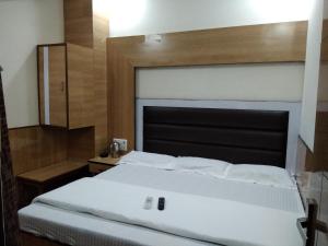 a bedroom with a white bed with a wooden headboard at Silver Palace Hotel in New Delhi