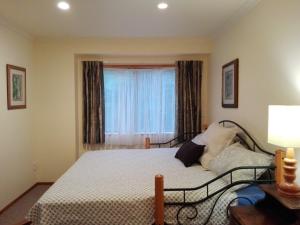 een slaapkamer met een bed voor een raam bij Taranaki Experience in New Plymouth