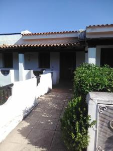 a white house with a white fence and a driveway at White Sand Residence in Murta Maria
