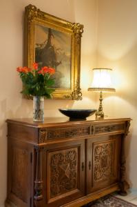 a wooden table with a mirror and a vase of flowers at Romantik Hotel Beau Rivage Weggis - Beau Rivage Collection in Weggis