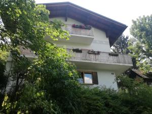 een wit gebouw met een balkon en bomen bij Privatzimmer Wagner in Leoben