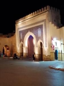 a building at night with a flag in front of it at Riad Elkorchi in Fez