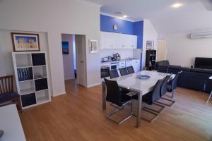 a living room and kitchen with a table and chairs at Golf and Beach Retreat in Albany