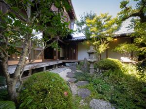 a garden in front of a building with a walkway at 内子の宿 こころ in Uchiko
