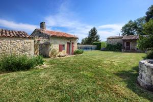 une ancienne maison en pierre avec une cour dans l'établissement Chambres d'hôtes Noailles, à Puisseguin