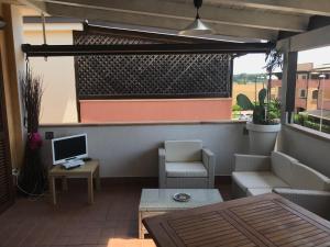 a patio with a couch and a desk and a computer at Blu Village 2 (MT) in Marina di Pisticci