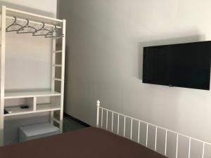 a flat screen tv hanging on a white wall at B&B Meliora Rooms in Avola