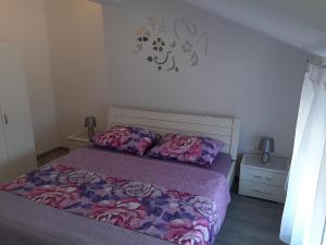 1 dormitorio con 1 cama con edredón morado en Apartmani Dream, en Pula