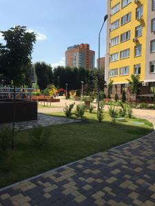 ein Park in einer Stadt mit Gebäuden und Gras in der Unterkunft Апартаменты на Каблукова in Kiew