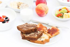 a white plate with bread and fruit on a table at Residence Villa Maurice in Stresa