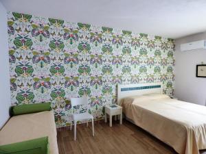 - une chambre avec un lit et du papier peint floral dans l'établissement Aramoni B&B, à Zambrone