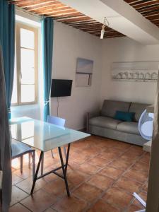 uma sala de estar com uma mesa e um sofá em Studios des Templiers em Hyères