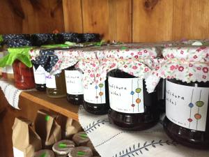 a group of jam jars on a shelf with wrapping paper at Lipowy dom in Piecki