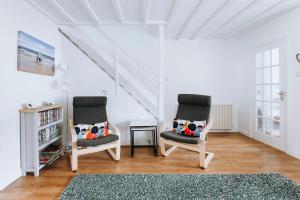 two chairs sitting in a living room with a rug at Inner Harbour Cottage in Portreath