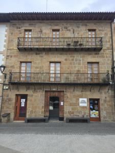 - un bâtiment en pierre avec 2 balcons au-dessus dans l'établissement PLAZA, à Segura