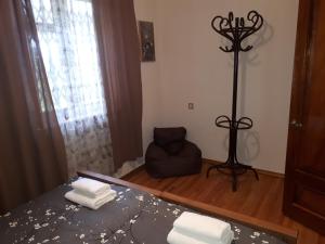 ein Schlafzimmer mit einem Bett und einem Stuhl in einem Zimmer in der Unterkunft Wine House KNIAZ in Sagarejo