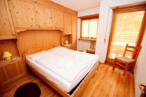 a bedroom with a bed and a chair in it at Apartment Sissi in Badia