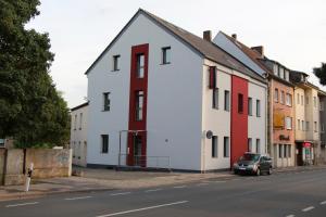 un bâtiment blanc et rouge sur le côté d'une rue dans l'établissement Aparts Oberhausen, à Oberhausen