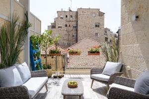 un balcón con sillas y una mesa y un edificio en Design & Veranda next to Mahane Yehuda Market by FeelHome, en Jerusalén