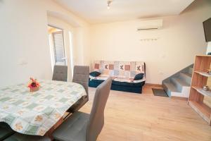 a dining room with a table and chairs and a couch at Linda Apartments Zambrattia in Savudrija