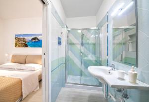 a bathroom with a shower and a sink and a bed at B&B La Gioia in Ischia