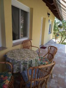 a table and chairs on a patio with a window at Apartment Kovacic Jurlina in Poljica
