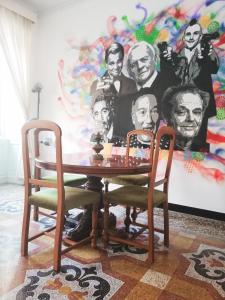 uma mesa e duas cadeiras num quarto com um mural em Leone X Genova Affittacamere em Gênova