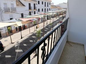 balcón con vistas a una calle con sombrillas en Hostal Ocaña Manilva, en Manilva